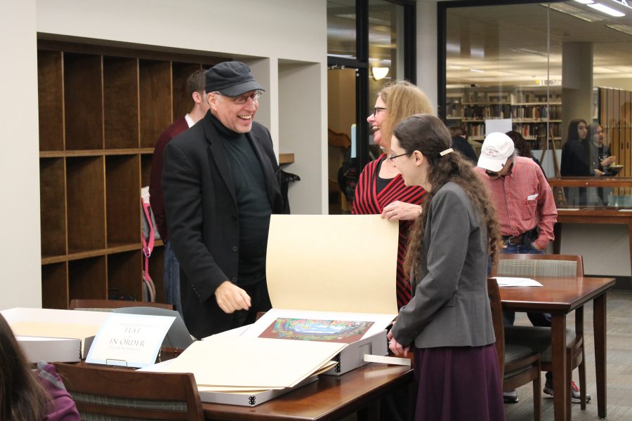 Photo by Ryan Silvola.
Director Philip Wm. McKinley discusses one of his set designs with Special Collections librarian Sarah Horowitz (on the right) and a community member. The McKinley papers will be on display until Dec. 12. 