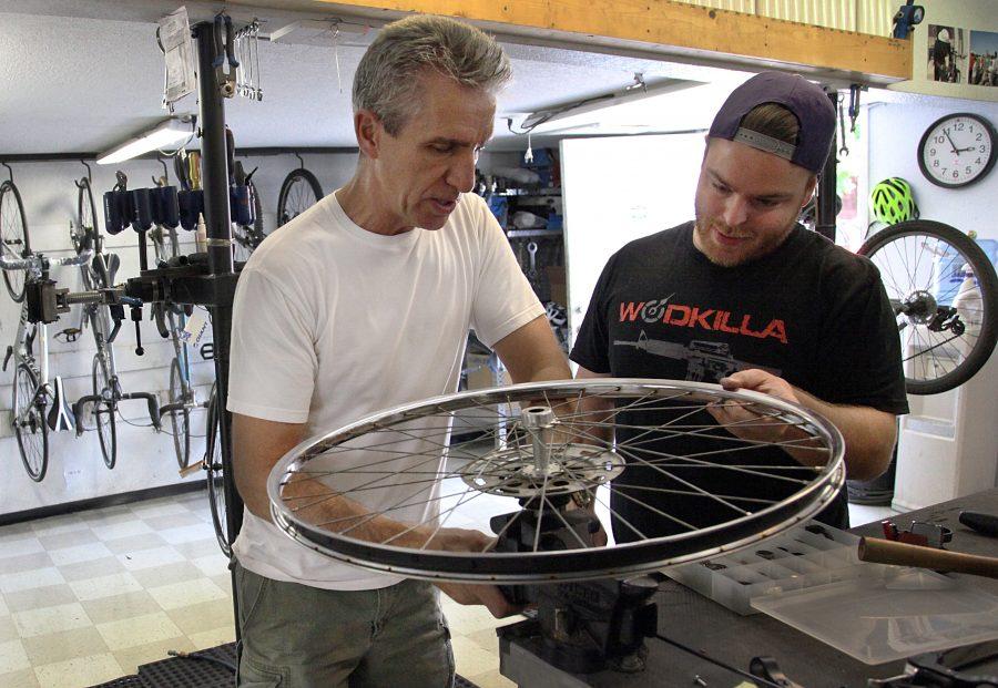 Local Bike and Hike owner Steve DePron assists cutsomer Brandon Coopman of Moline with the wheel of his bicycle. His shop is located on 14th Avenue in Rock Island.
Photo by Linnea Ritchie.