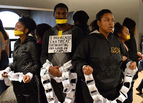(Left to right) sophomores Crystal Gray and Denzel Woodall and junior Vicky Gillon chain themselves together to protest racial injustices. Photo by Ryan Silvola.