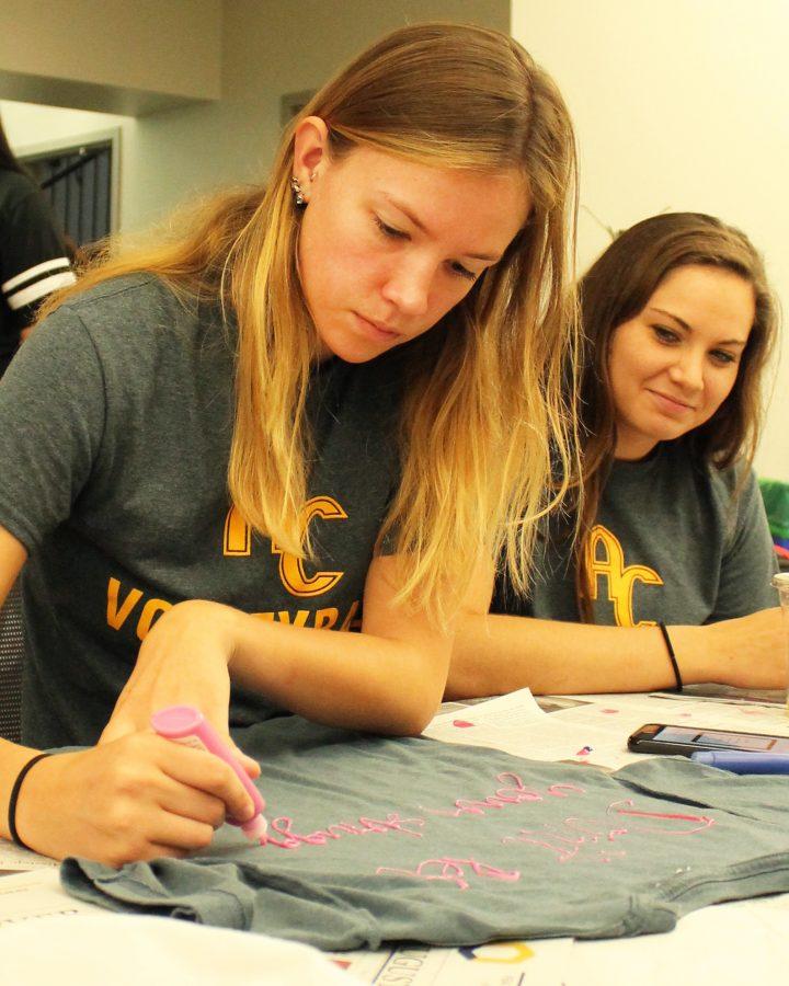 Volleyball players Rachel Butters and Taryn VanEarwage write messages on shirts as part of the Clothesline Project during Symposium Day on Sept. 17.
Photo by LuAnna Gerdeman.