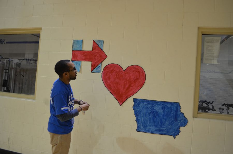 A Hillary Clinton campaign worker tapes up signs of support around the gymnasium at Davenports Williams Intermediate School prior to the start of the Iowa Caucus on Feb. 1. 