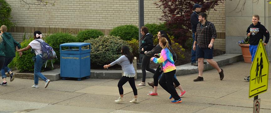 Participants flee from Centennial Hall during the active shooter drill on April 26. 