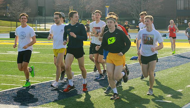 Members of the Mens distance crew run a warm up lap at practice. Photo by Tawanda Mberikwazvo.