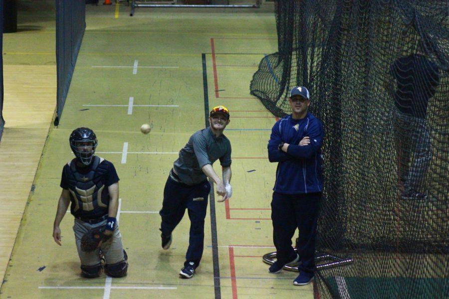 Baseball pitching coach Justin Hauer works with junior Jack Hallmark during practice. The Vikings will play two CCIW teams this weekend. Photo by Tawanda Mberikwazvo.