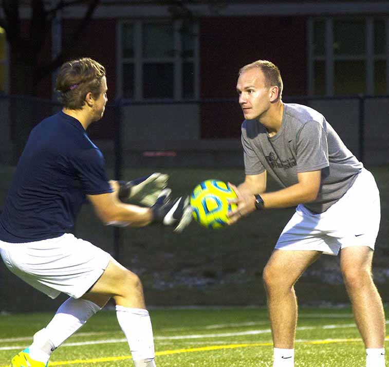 Assistant mens soccer coach Joe Sagar runs his goalkeepers through warm up drills to help them prepare for the upcoming game. Photo by Jordyn Strange