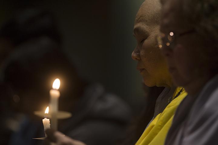 The Su Co of the Quam Nam Buddhist Temple, in East Moline, sits silently during the remembrance. 