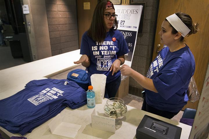 (left to right) Vanessa Perez (18) and Meghan Graham (19) sell shirts for Best Buddies at the basketball game on Saturday. Photo by Kevin Donovan
