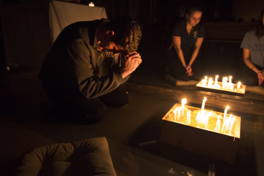 Jacob Speechley (18), president of Phi Omega Phi, bows his head during the candlelight vigil on Wednesday night in support of sexual assault survivors. Photo by Kevin Donovan