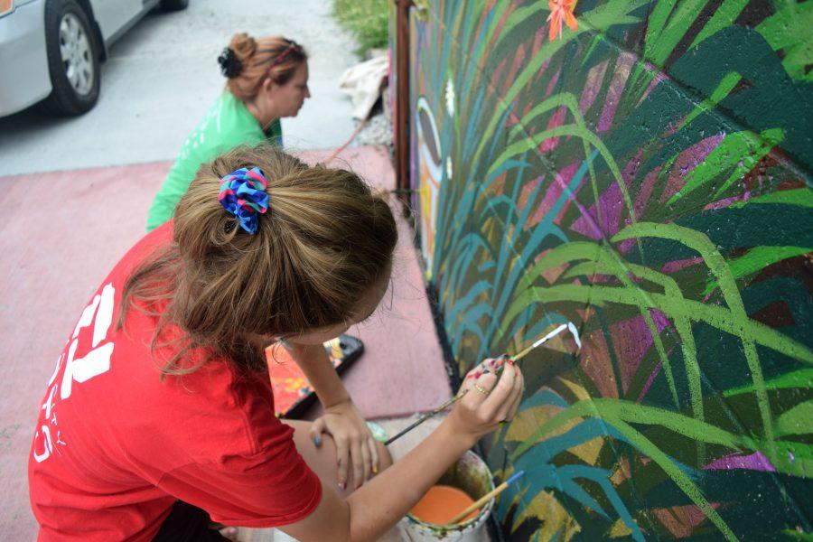 Local artists with Quad City Arts paint details on plants on the last day of their project. After nine days, the mural will be finished and ready for public viewing on Monday, July 23. 