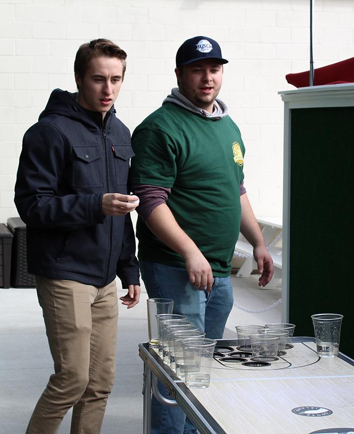 Partners in water pong decide their next shot at Oktoberfest.