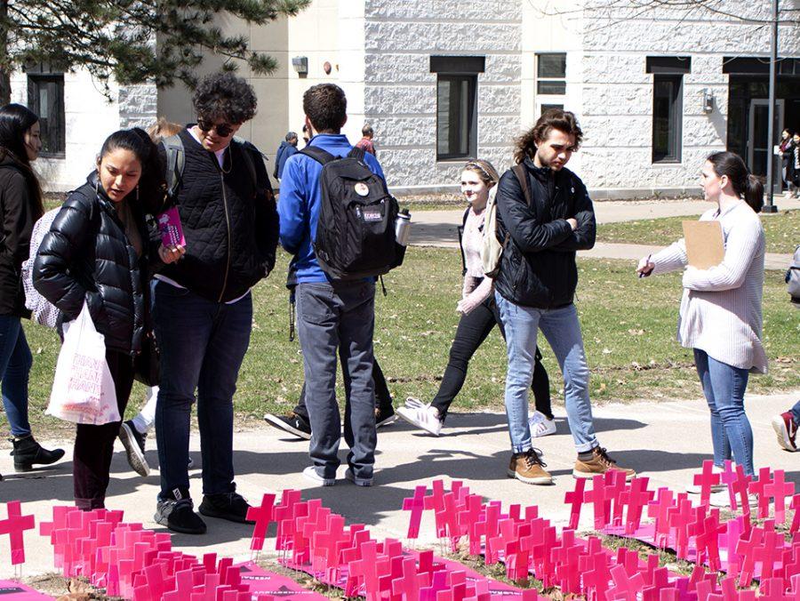 Students gather to look at the pink crosses in the pro-life clubs display on Monday, April 1. Each of the 911 crosses signifies an abortion performed at Planned Parenthood each day. Photo by Emily Jacobson.