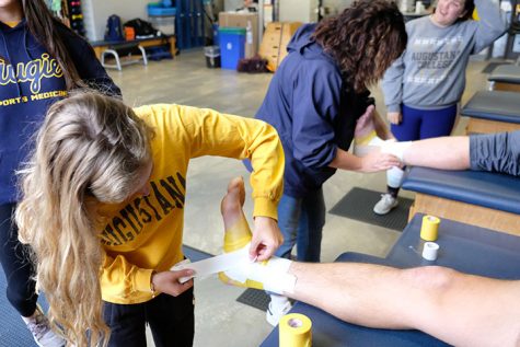 Sophomore athletic trainer Madison Bonati wraps an ankle alongside certified trainer Denise Yoder (in Augie’s sports medicine clinic) on Wednesday.