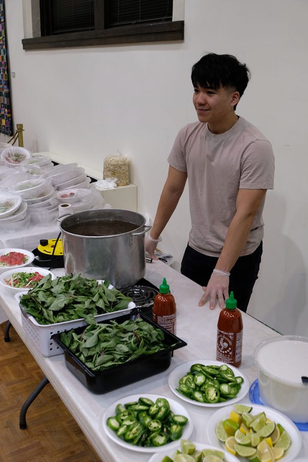Sophomore Long Nguyen helps staff the Pho-Tastic event in Wallenburg Hall on Saturday night.