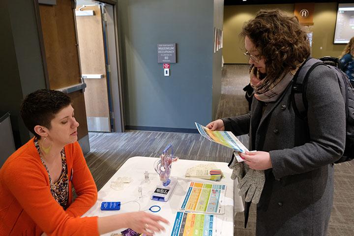 Dr. Lena Hann speaks with Katie Oestmann at the Sexual Health Fair on Friday. 