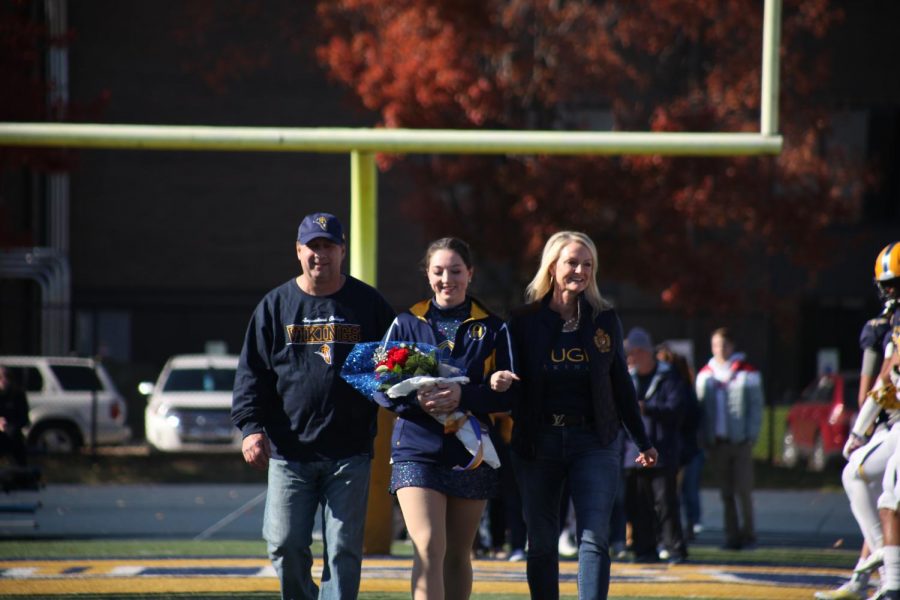 Senior Vikette Ariana Pullara walks with her parents at the football game on Saturday, Nov. 6, 2021.
