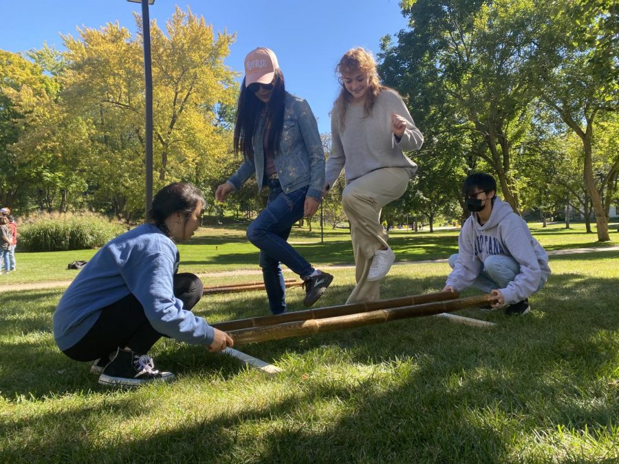 Professor Hua-Mei Chang doing a bamboo pole dance with freshman Caitlin Morse. Isabella Smart and Anna Ranberg, two sophomore students taking Chinese, moving the bamboo poles to the rhythm.