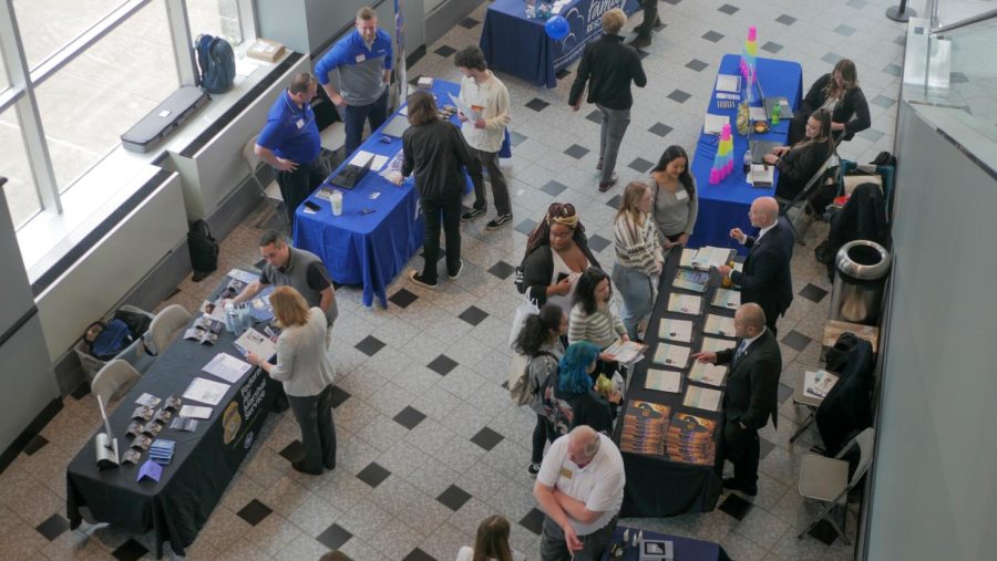 A busy corner of the convention center, with students and representatives from different employers attending the Career Fair.