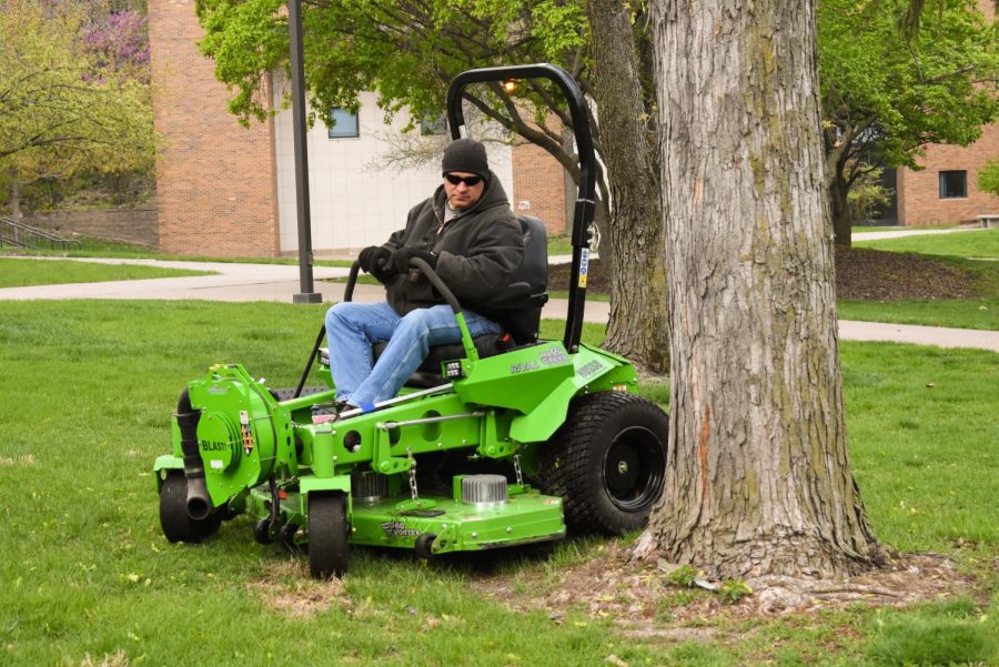Chris Woods mows the lawn through the quad.