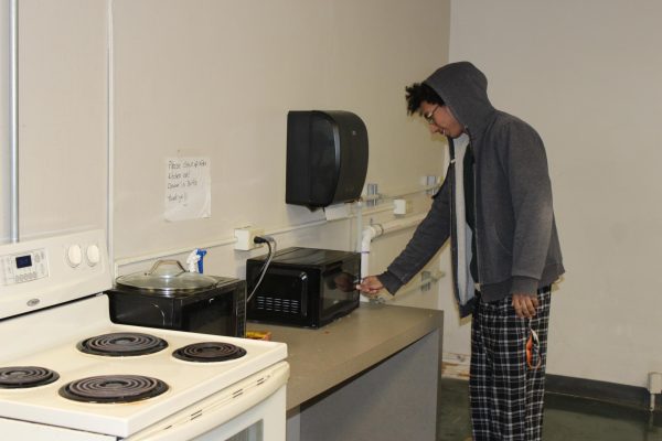 First-Year Moss Truman cooks using the microwave in the Westerlin kitchen area.