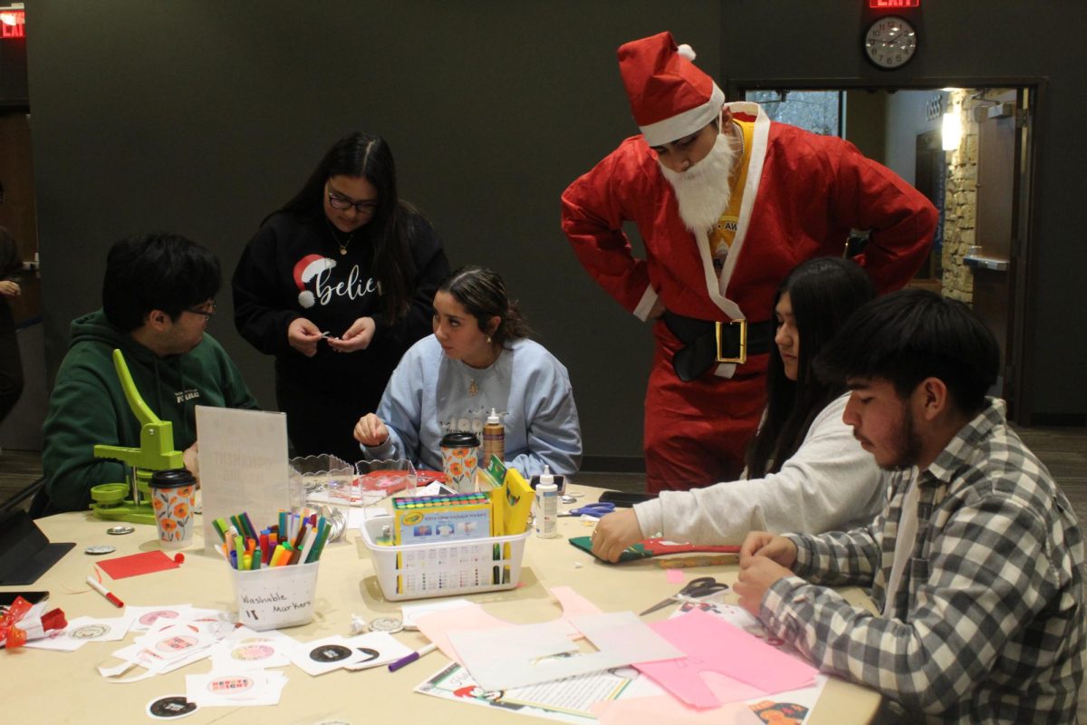 A student in a Santa Claus costume interacts with the students at the “Holidays Around The World” in the Gavle Rooms.