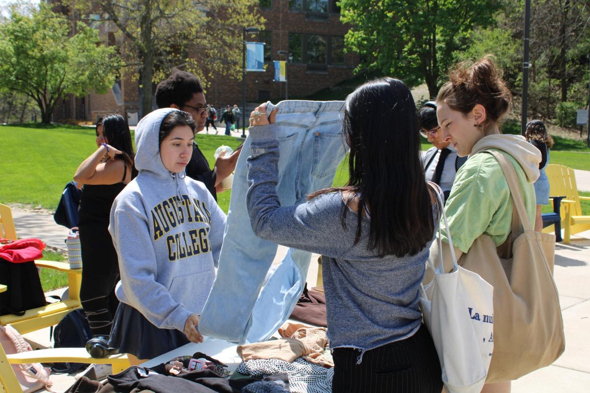 Volunteer Amy Aartega, sophomore, assists Juniors Josie Banjara and Sawyer Graham in swapping clothes during the Swap Don’t Shop event at the Lower Quad on April 25, 2024.