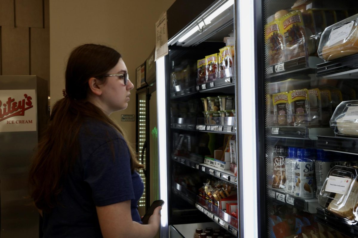 Junior, Madeline Hutchinson looks at the shelves of the Westerlin C-store and contemplates what to buy with her meal swipe.