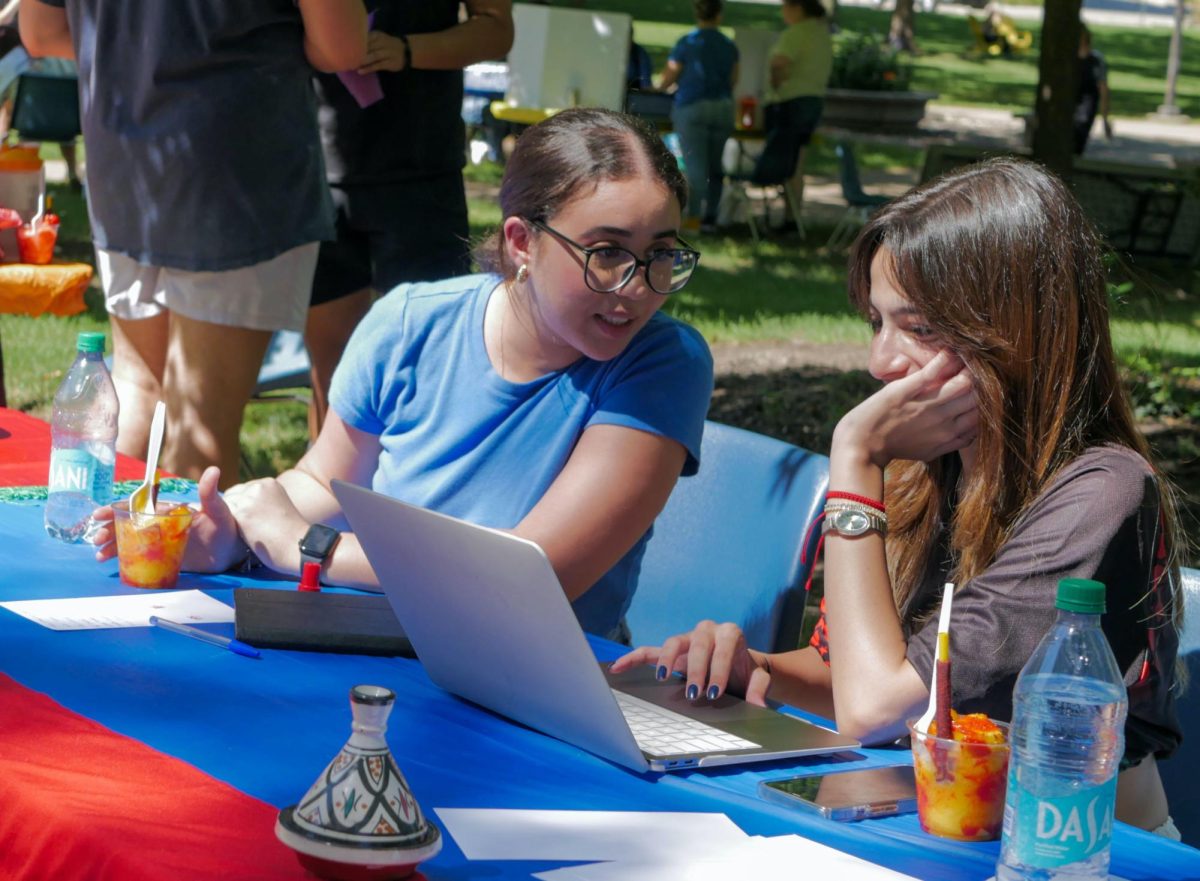 Senior Rime Tlih and junior Nisrine Ouinaksi discuss plans for the school year at the Moroccan Student Association table at the annual Office of Student Life Activities Fair on Aug 31, 2024. 