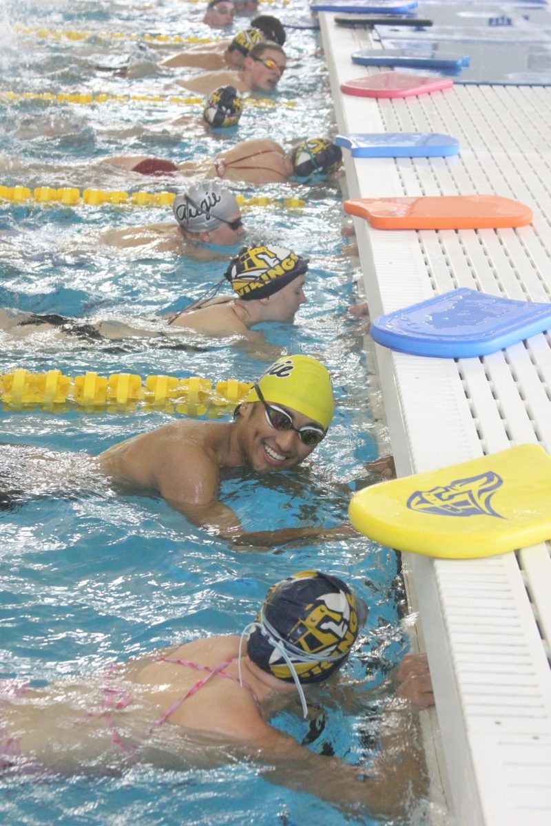 Senior Nathan Mesina talks to other members while practicing at the Anne Greve Lund Natatorium on Sept. 27.