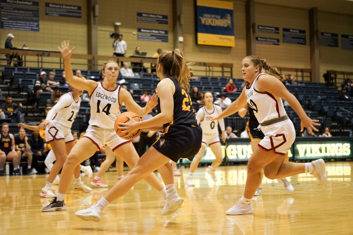 Team Captain Senior Emma Berg surrounded by defenders during the home game against the Edgewood Eagles at the Roy J. Carver Center on Nov. 16, 24. The Augustana Vikings won their first game of the season decisively, with a score of 73-47.