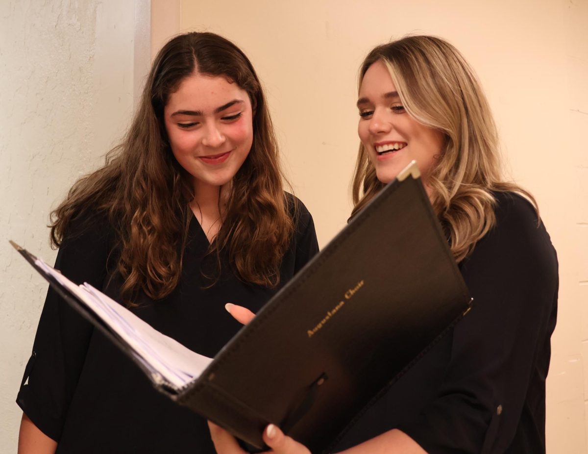 Junior Genevieve Ryan and Senior Julie Tarling rehearse their part during the Augustana Choir practice on Tuesday, Oct. 29. Both of them participate in Midsummer Night’s Dream, a collaboration between the Choir and the Quad Cities Symphonic Band.