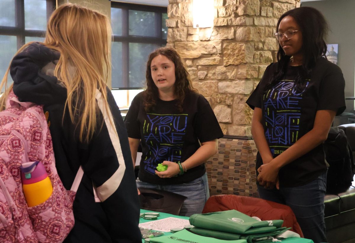 NAMI’s president Maya Doss (right) and vice president Zoe Snell chat with a student about mental health resources on campus during NAMI’s  ‘Let’s Taco About Mental Health’ hosted in the Brew on Oct. 24