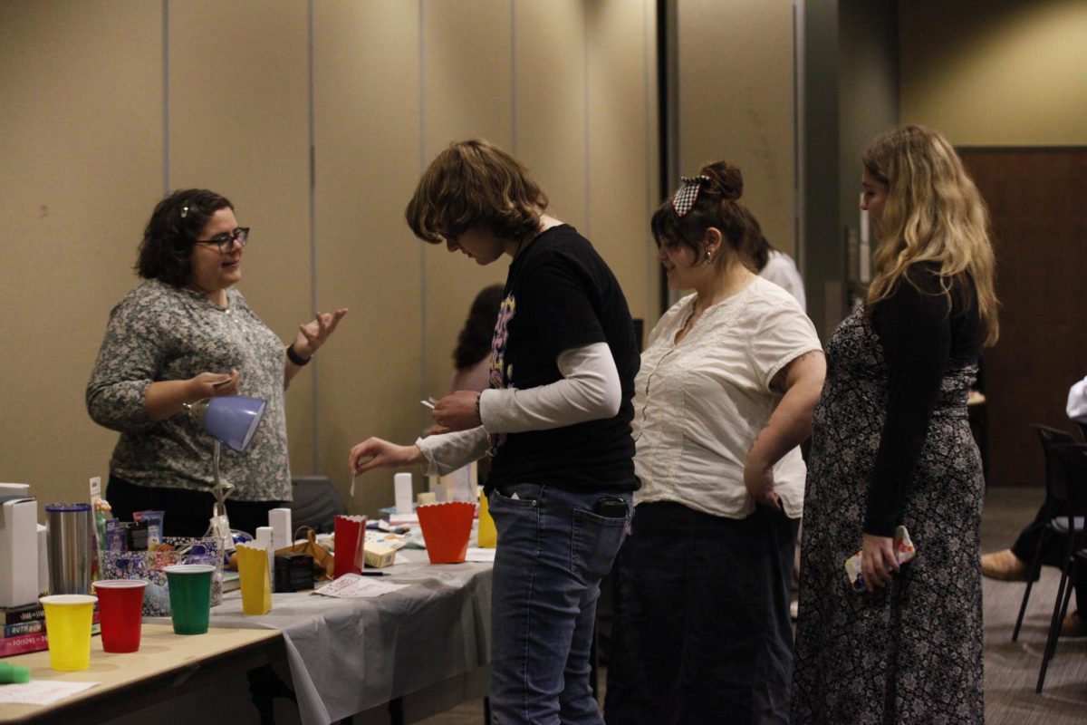 Students gather around a table filled with colorful cups and snacks during a fundraising event for the Neurodivergent Student Union (NDSU) on Nov. 21, 2025, in the Gavle Rooms.