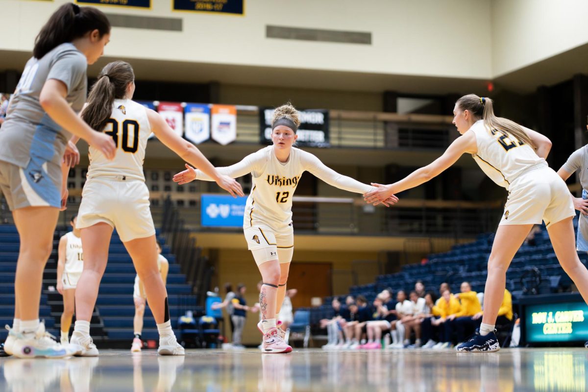 Augustana Vikings guard Audrey Erickson (12) receives high-fives from teammates during a break between free throw attempts in the Vikings' 81-56 victory over the Elmhurst Bluejays on Feb. 18 at the Roy J. Carver Center. The win marked the final home game of the season for the Vikings.