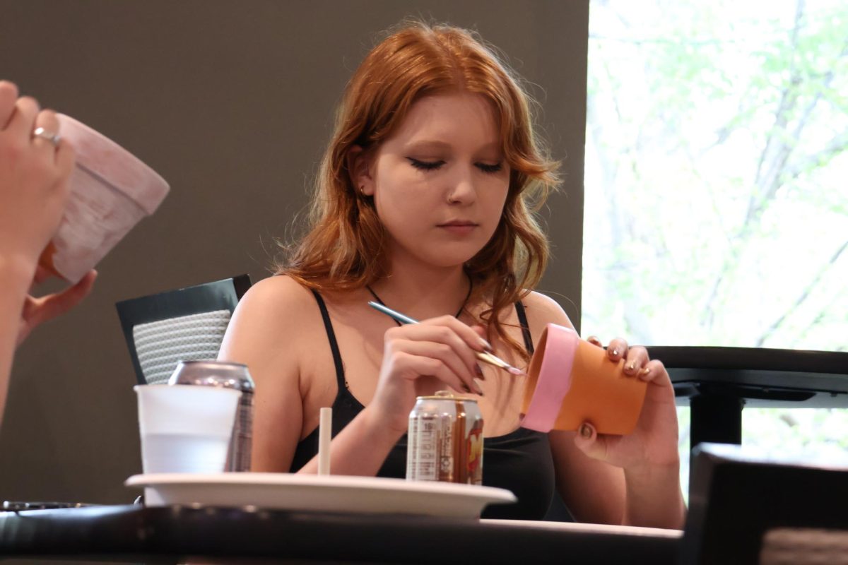 Corina Rab, sophomore, paints a pot in celebration of Earth Day during the Office of Student Life's Earth Week activities in the Brew on April 23, 2026